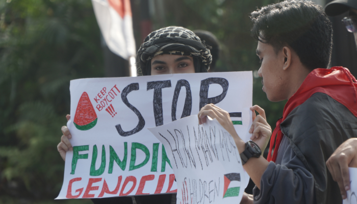 Poster Seruan Untuk Stop Genocide di Palestina Dibentangkan Oleh Salah Satu Peserta Aksi Voice of Palestine - www.infomalangraya.co.id